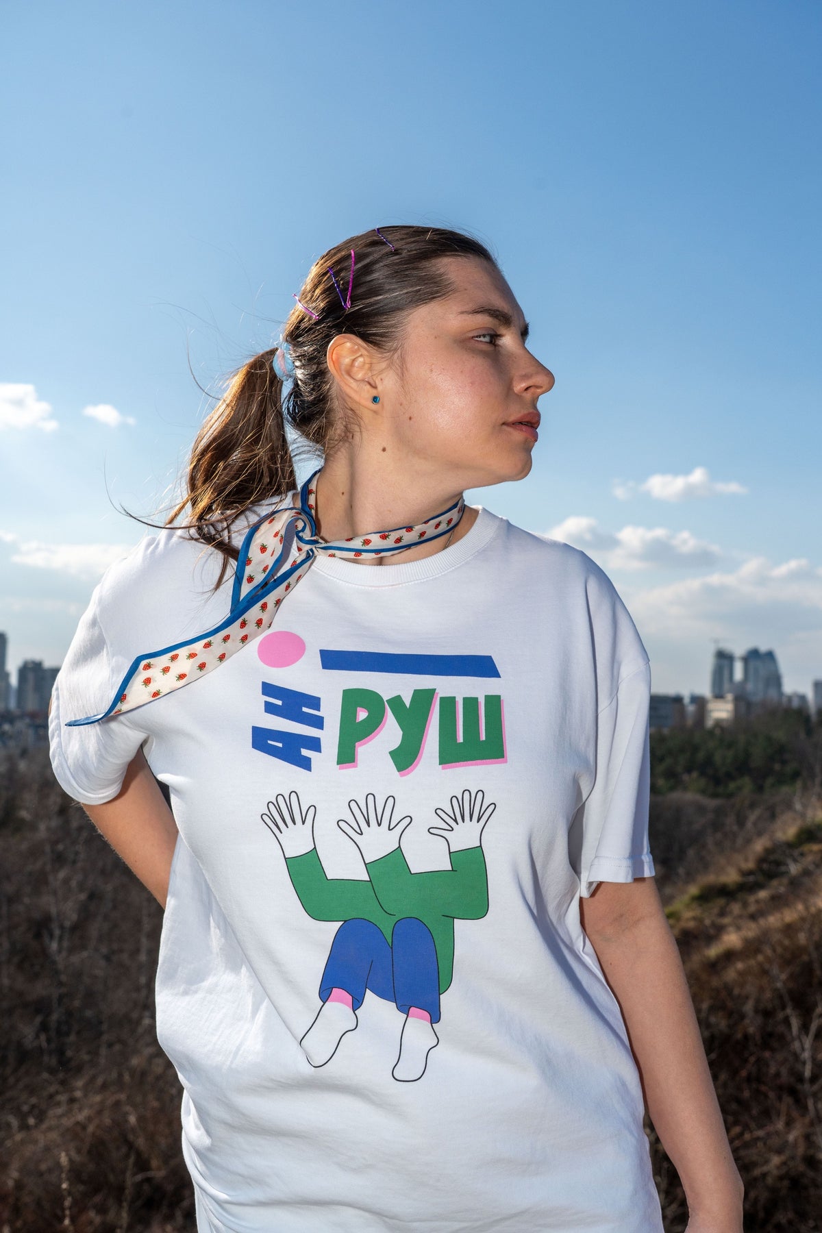 Woman wearing the white Ani Rush T-shirt with its illustrated print