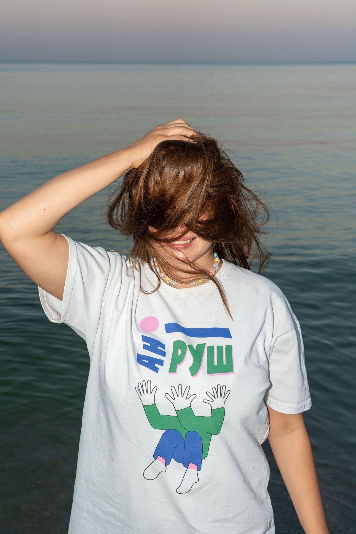 Model wearing the white Ani Rush T-shirt with its illustrated print